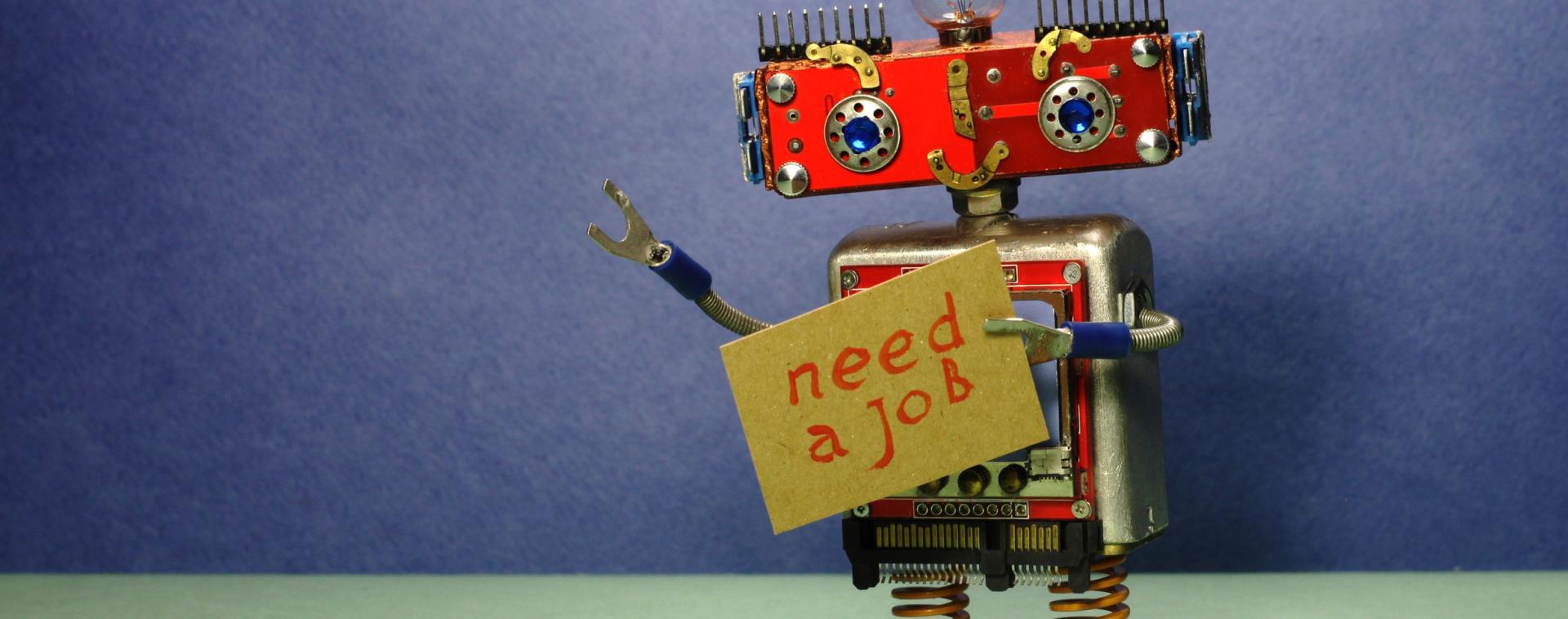 a robot holding a sign that says 'need a job'